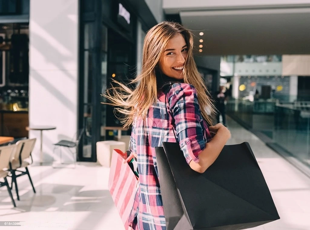 Happy girl with shopping bags looking over shoulder