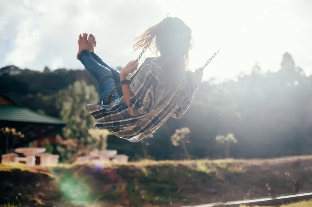 stock photo back view of happy barefoot girl on swing in sun light carefree woman 609282206 transformed