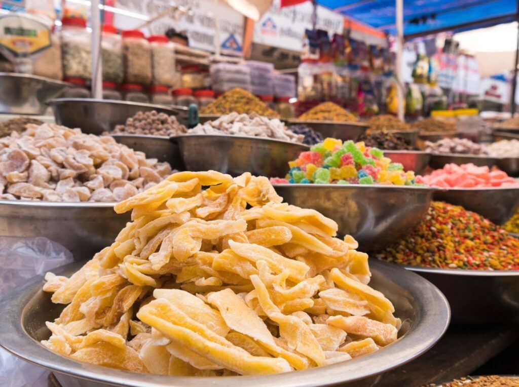 dried mango in stainless bowl with many kind of dried fruits, sweets and spices in stall at Manek Chowk, Ahmedabad, India.