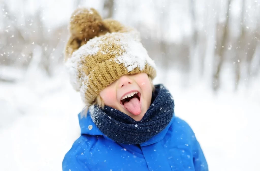 stock photo funny little boy in blue winter clothes walks during a snowfall outdoors winter activiti