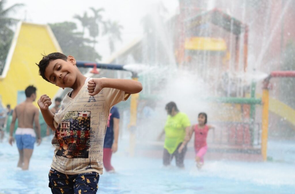 Young unidentified boy enjoying in water park or amusement park in sunny summer day in Nicco Park kolkata.