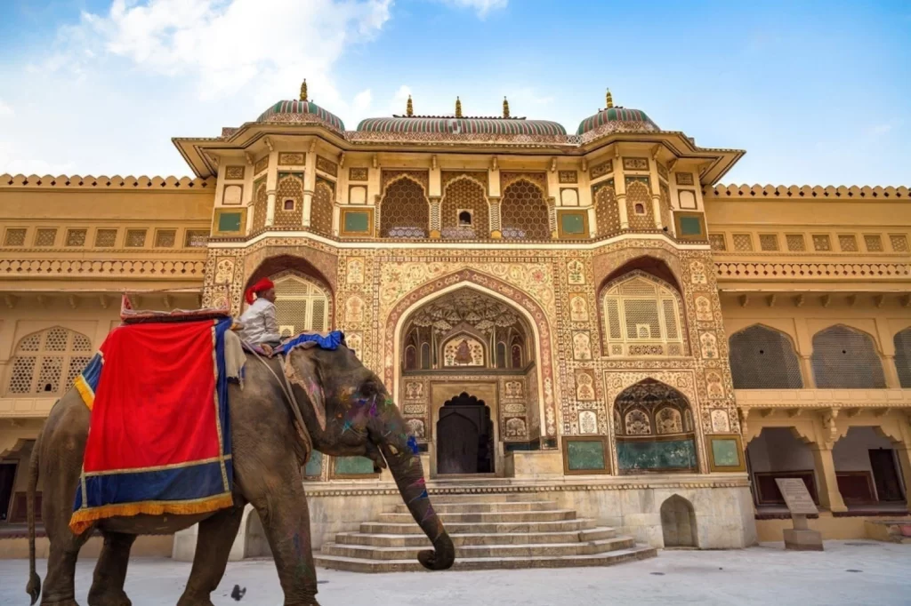 Decorated Indian elephant in front of Amer Fort Palace Jaipur intricately carved gateway. Amber Fort is a UNESCO World Heritage site.